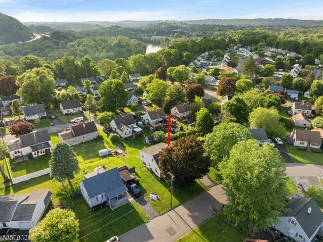 an aerial view of residential houses with outdoor space and trees