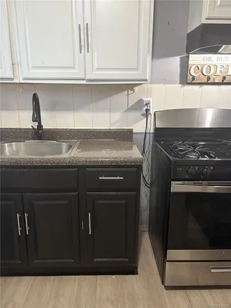 a kitchen with granite countertop white cabinets and stainless steel appliances
