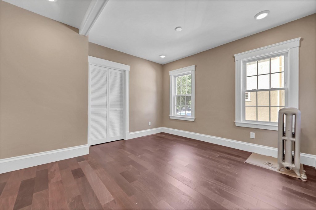 1540 Mystic Valley Parkway, Unit 1 Medford, MA 02155 - Photo 11 of 17 an empty room with wooden floor and windows