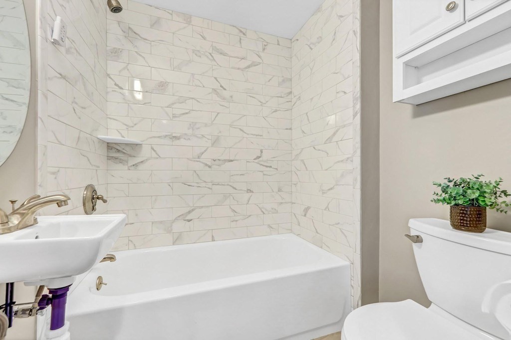 1540 Mystic Valley Parkway, Unit 1 Medford, MA 02155 - Photo 14 of 17 a white bath tub sitting next to a white toilet
