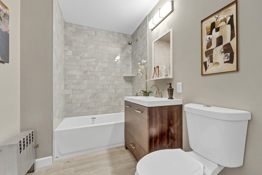 1540 Mystic Valley Parkway, Unit 1 Medford, MA 02155 - Photo 10 of 17 a bathroom with a toilet a sink and bathtub