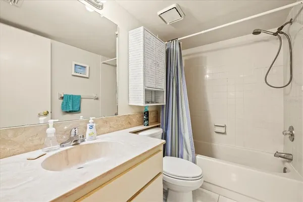 a bathroom with a granite countertop sink a toilet and a large mirror