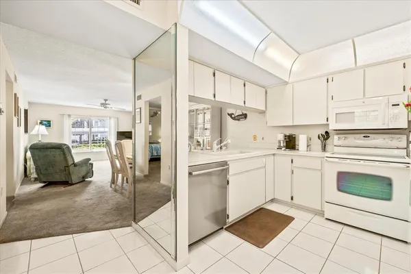 a kitchen with white cabinets and appliances