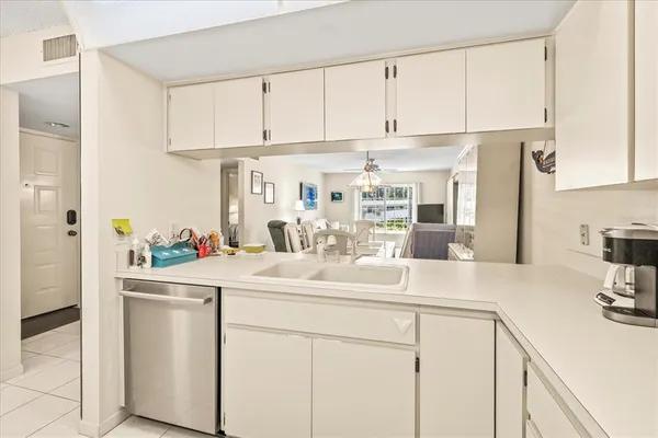 a kitchen with white cabinets and sink