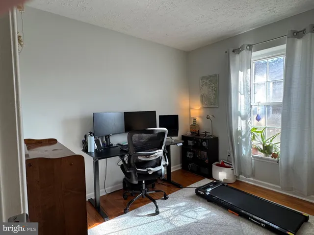 a view of a workspace with furniture and a window