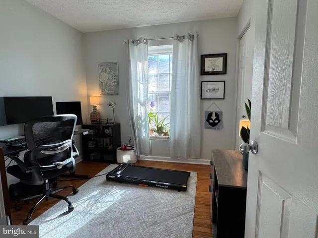 a view of a workspace with furniture and a window