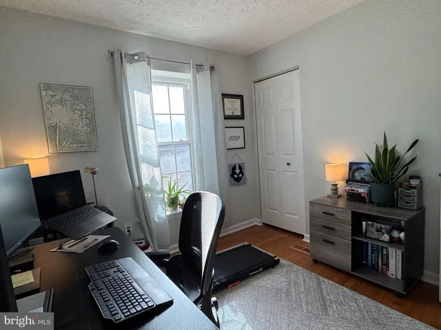 a view of a workspace with furniture and a window