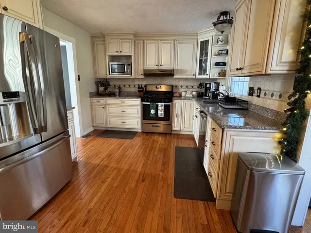 a kitchen with stainless steel appliances granite countertop a refrigerator a stove top oven a sink and dishwasher