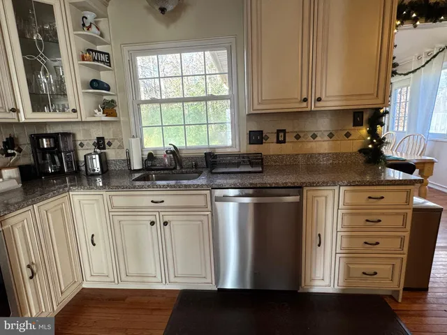 a kitchen with stainless steel appliances granite countertop a sink a stove and cabinets