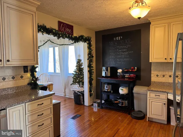 a kitchen with a wooden floor and a refrigerator