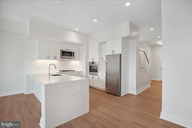 a kitchen with stainless steel appliances a refrigerator sink and stove