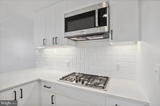 a kitchen with stainless steel appliances white cabinets and stove