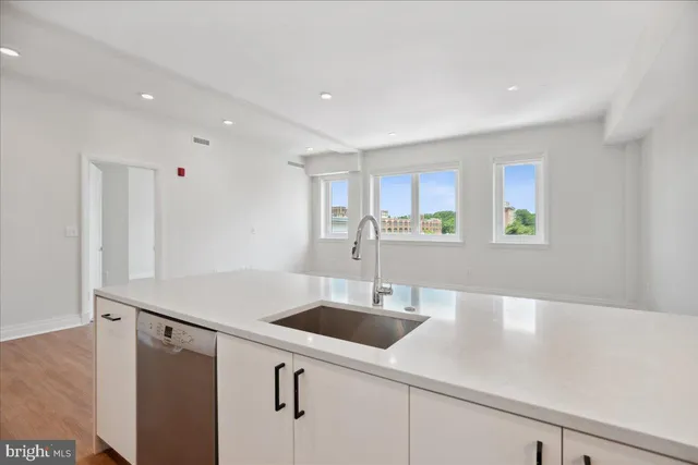 a kitchen with stainless steel appliances a refrigerator a stove and white cabinets