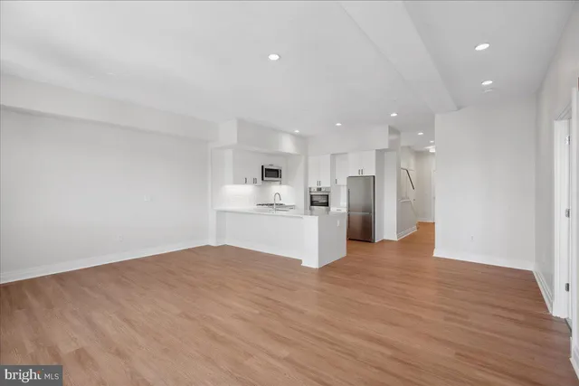 a kitchen with stainless steel appliances kitchen island granite countertop a refrigerator and a stove top oven