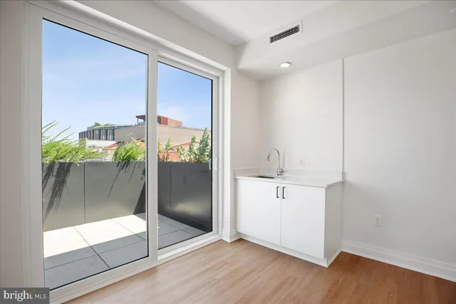 a view of a big room with an empty room and wooden floor