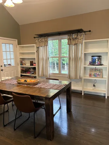 a kitchen with a table chairs and wooden floor
