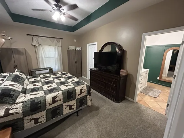 a spacious bedroom with a bed and a flat screen tv