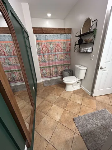 a bathroom with a toilet and a shower