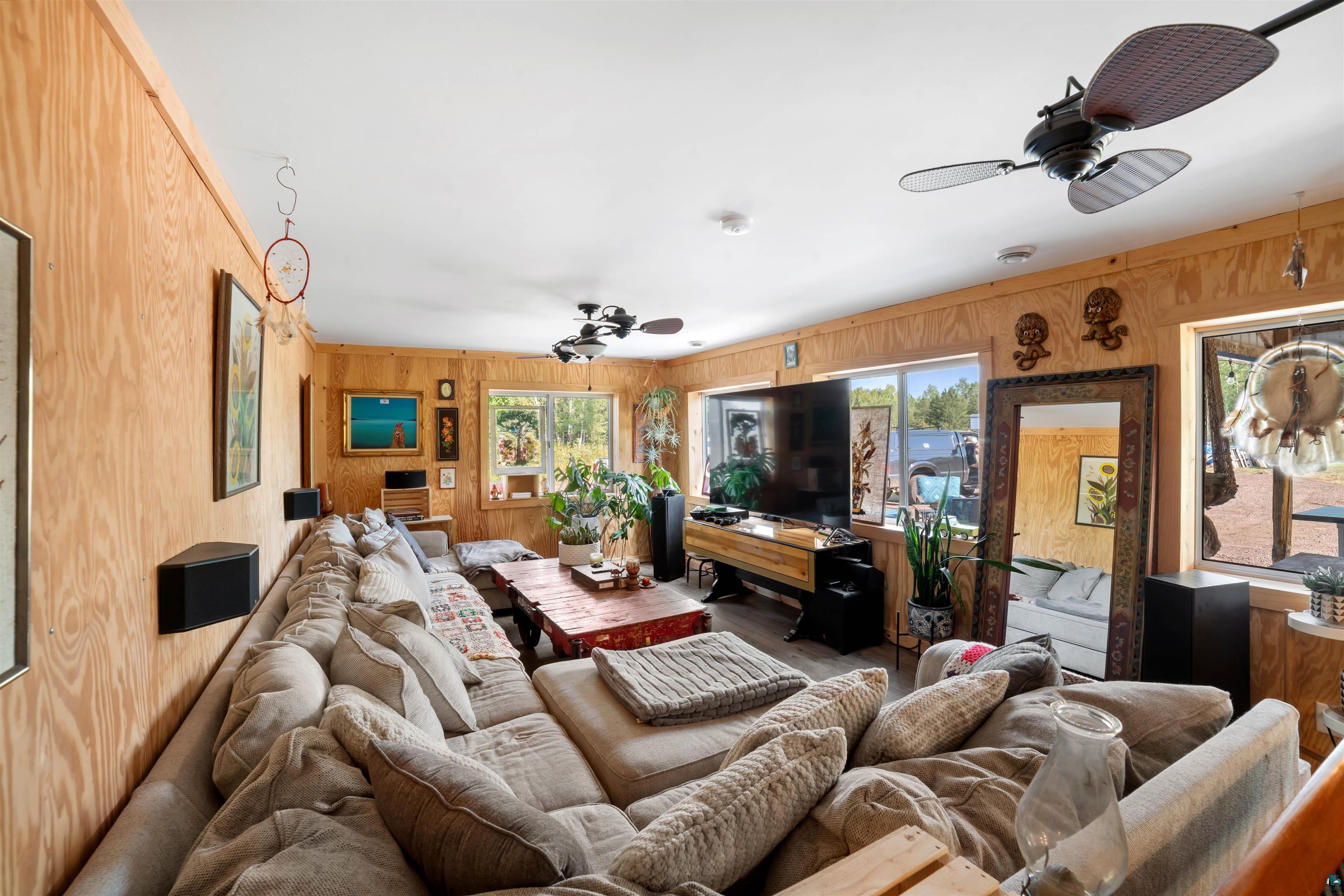 1159 East County Rd B Foxboro, WI 54836 - Photo 14 of 29 Living room with wood walls, ceiling fan, and plenty of natural light