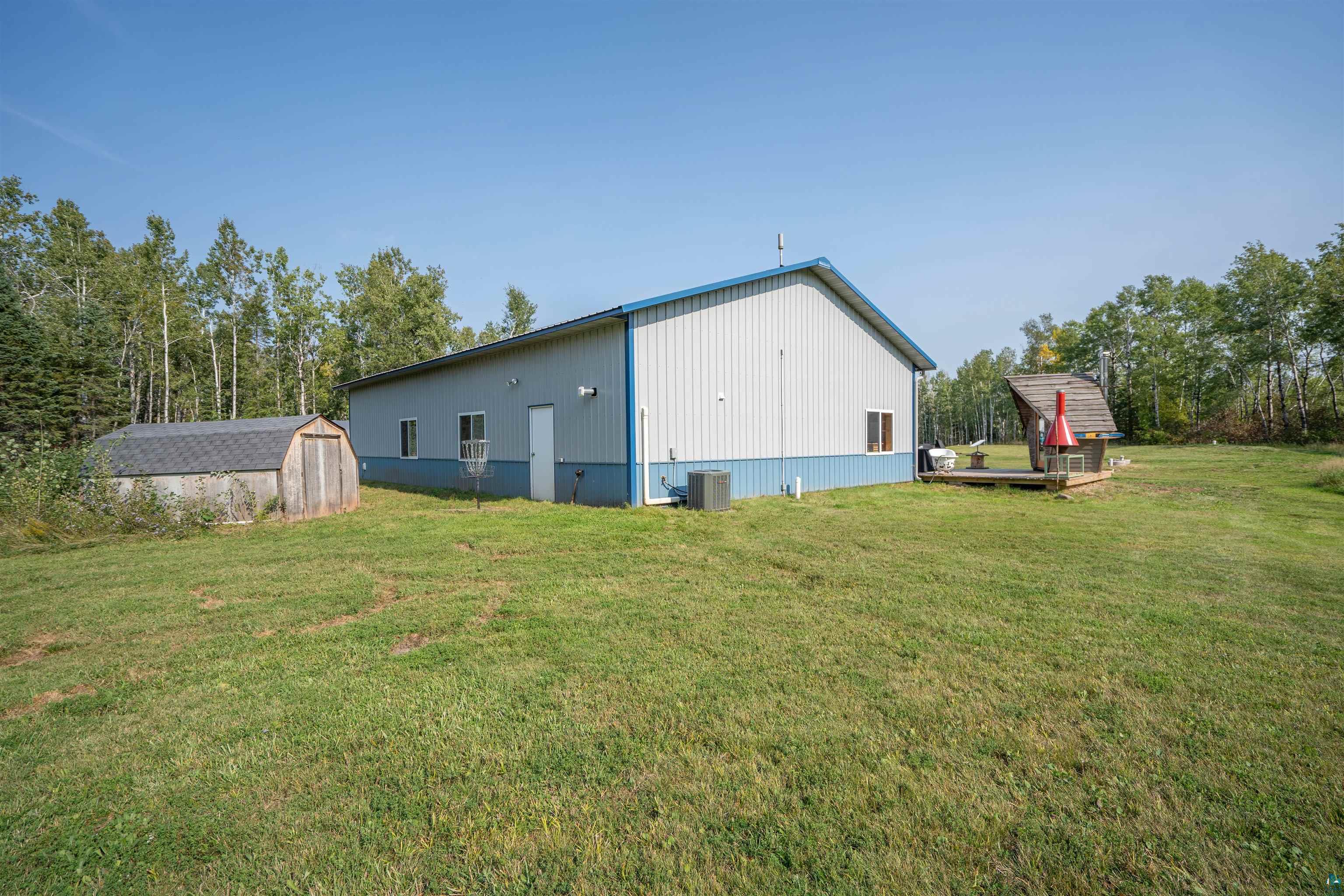 1159 East County Rd B Foxboro, WI 54836 - Photo 29 of 29 Exterior space with a storage unit, a yard, and central AC
