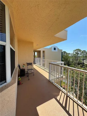 a balcony with wooden floor and outdoor seating