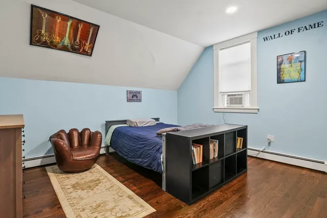 a living room with stainless steel appliances furniture a rug and a window