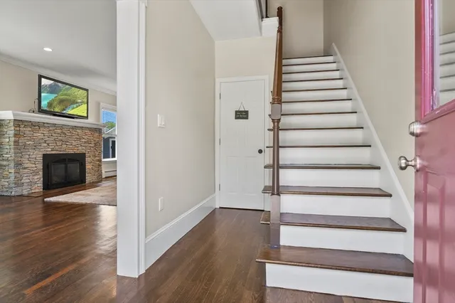 a view of an entryway with wooden floor and a fireplace
