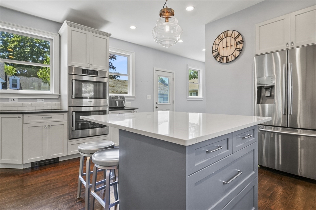 5 Waban Street Natick, MA 01760 - Photo 7 of 32 a kitchen with kitchen island granite countertop stainless steel appliances a large counter top space cabinets and a window