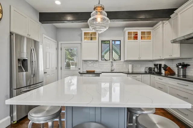 a kitchen with stainless steel appliances granite countertop a kitchen island hardwood floor sink and stove