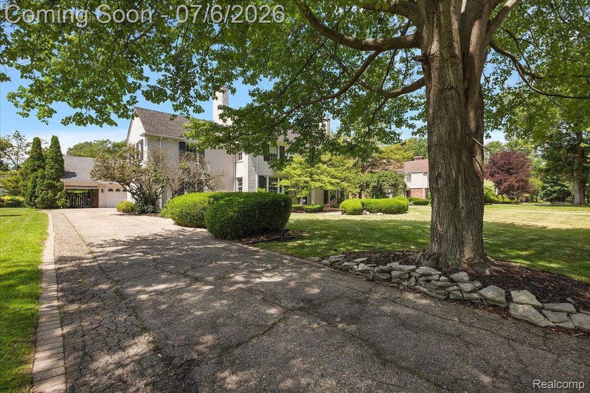 1051 Devonshire Road Grosse Pointe, MI 48230 - Photo 89 of 98 Expansive front yard featuring a mature tree with stone surround and a paved driveway with brick edging