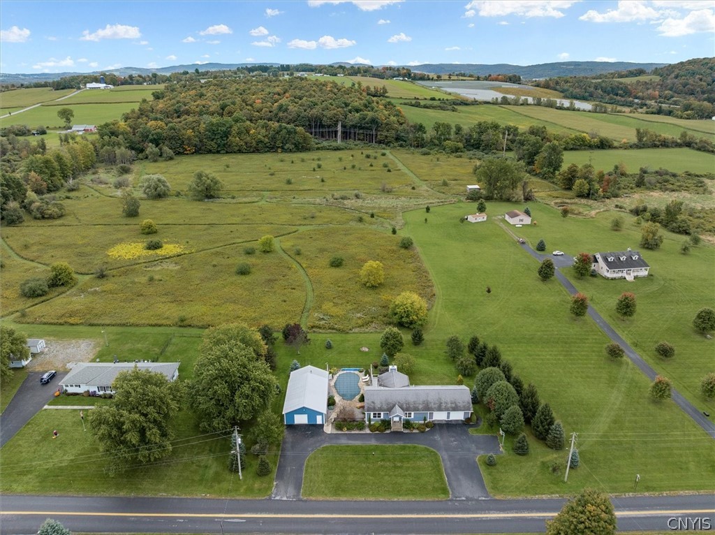 1322 Sawmill Road Sangerfield, NY 13480 - Photo 8 of 50 A sweeping aerial view showcases the vast rural property surrounded by rolling green hills.