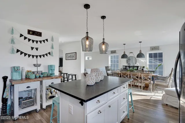 a view of a dining room and livingroom with furniture wooden floor a chandelier