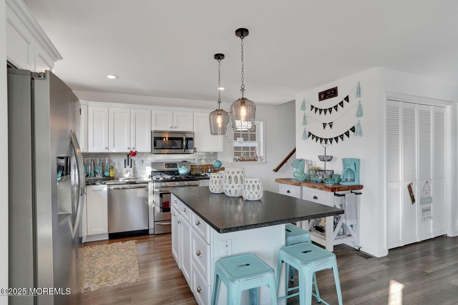 304 6th Avenue Seaside Heights, NJ 08751 - Photo 4 of 20 a kitchen with stainless steel appliances granite countertop a sink dishwasher a refrigerator a stove a dining table and chairs with wooden floor