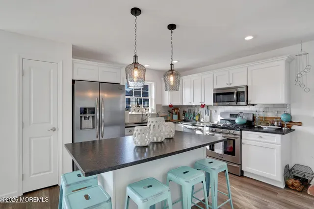 a kitchen with stainless steel appliances granite countertop a sink a stove and refrigerator