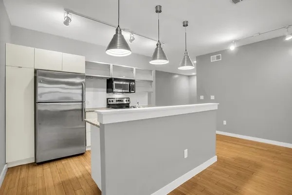 a kitchen with stainless steel appliances a refrigerator a sink and a stove
