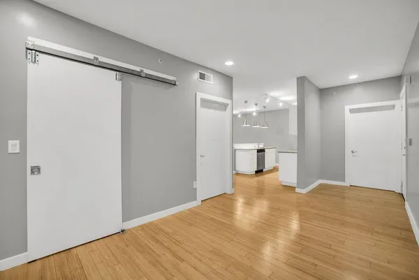 a view of empty room with wooden floor