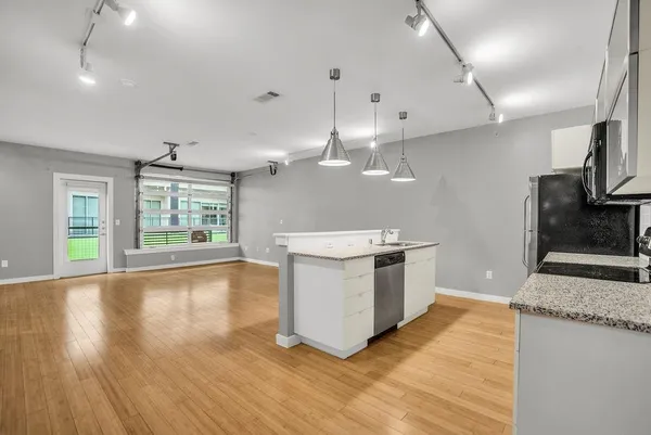 a large kitchen with kitchen island a large counter space a sink appliances and cabinets