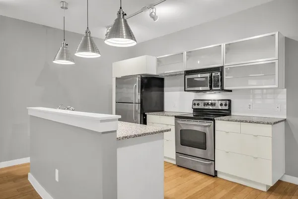 a kitchen with stainless steel appliances a stove a microwave and a refrigerator