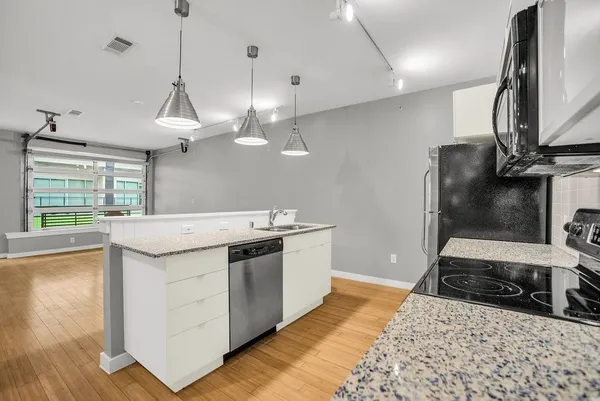 a kitchen that has a sink a stove and a wooden floor