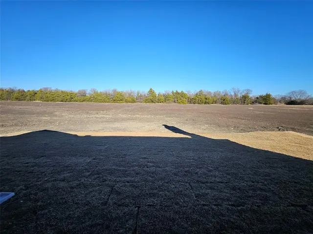 an empty room with a ceiling fan and window