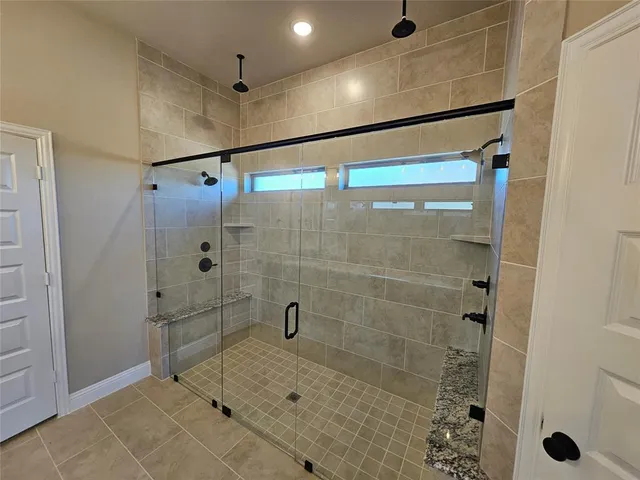 a bathroom with a granite countertop sink double vanity and a mirror