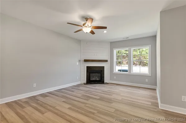 a view of empty room with fireplace and fan