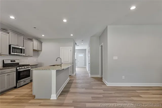 a large kitchen with stainless steel appliances granite countertop a stove and a sink