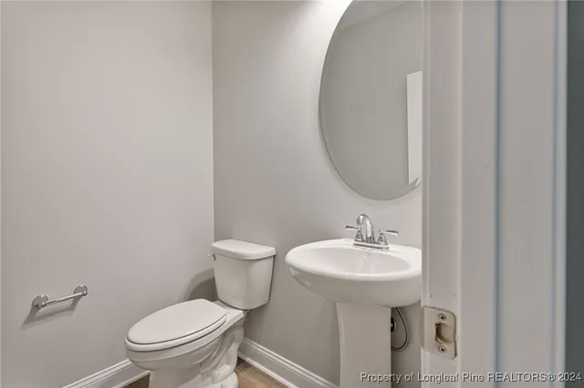 a bathroom with a sink toilet and a mirror