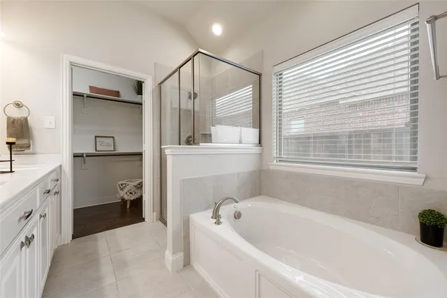 a bathroom with a tub sink and mirror
