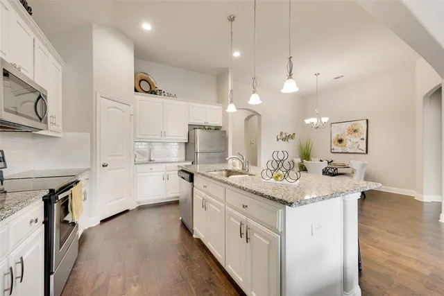 a kitchen with stainless steel appliances sink stove and cabinets