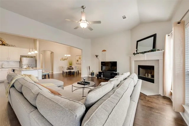 a living room with furniture a fireplace and a chandelier