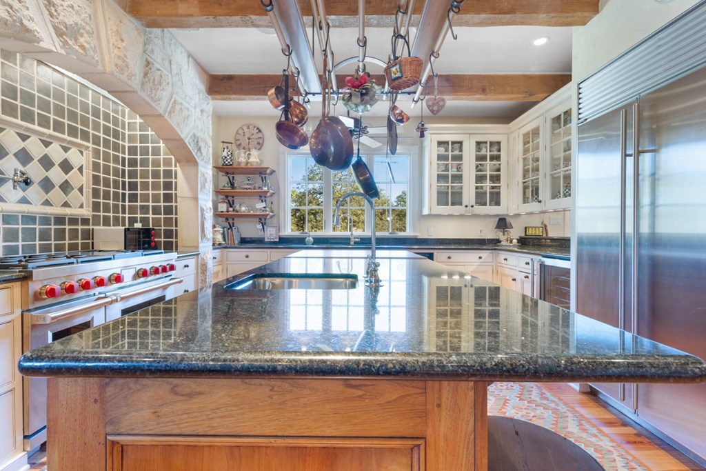 1129 Triple Creek Road Fredericksburg, TX 78624 - Photo 24 of 78 a kitchen with granite countertop a sink and dishwasher