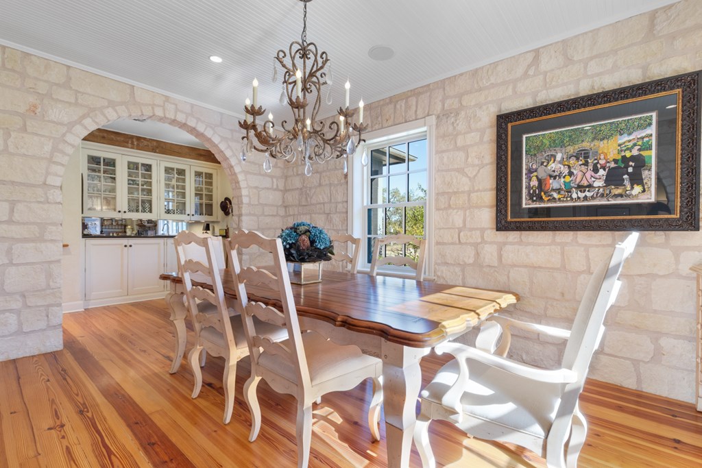 1129 Triple Creek Road Fredericksburg, TX 78624 - Photo 25 of 78 a view of a dining room with furniture a chandelier and wooden floor
