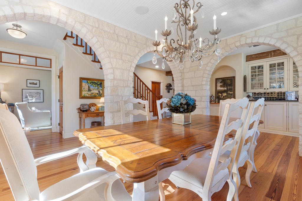1129 Triple Creek Road Fredericksburg, TX 78624 - Photo 26 of 78 a view of a dining room with furniture a chandelier and wooden floor